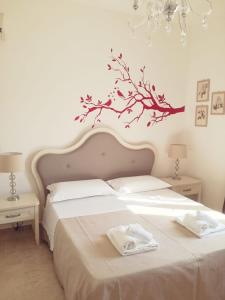 a bedroom with a bed with a branch on the wall at Il Mirto Blu in Porto Cesareo
