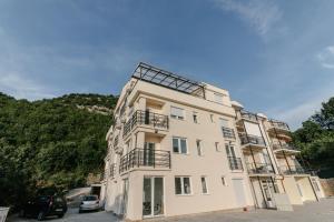 a tall white building with balconies on the side of it at Apartments Lakeside Elesec in Ohrid