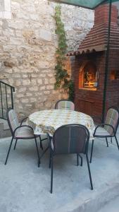 een tafel en stoelen met een tafel en een open haard bij Apartman Lucijan in Kaštela