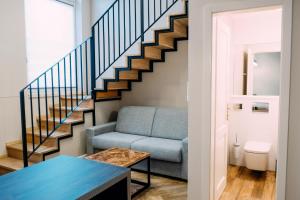 a living room with a blue couch and stairs at Penzión Flámm in Rajecké Teplice