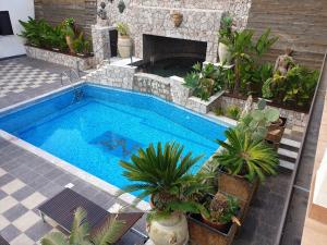 an outdoor swimming pool with a stone fireplace and plants at Villa Antheus in Graniti