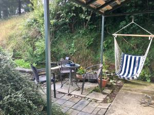 a patio with chairs and a table and a hammock at Five Saints Farmhouse B&B in Pumpsaint