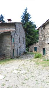 un vecchio edificio in pietra con una panchina davanti di SO MAGIC - La casa nel bosco a San Godenzo