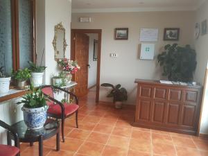 sala de estar con mesa, sillas y plantas en Hostería Carmen, en Santillana del Mar
