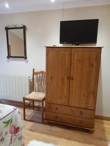 a television on top of a wooden cabinet in a room at Hostería Carmen in Santillana del Mar