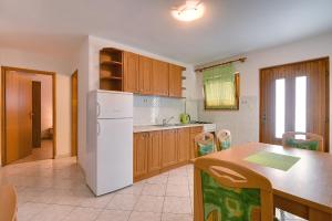 kuchnia z białą lodówką i stołem w obiekcie Holiday Home Mihael w Medulinie