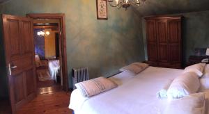 ein Schlafzimmer mit einem großen weißen Bett in einem Zimmer in der Unterkunft Hotel Peñalba in La Riera