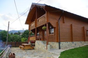 una baita di tronchi con veranda e patio. di Eco Sadyba Familia a Jaremče