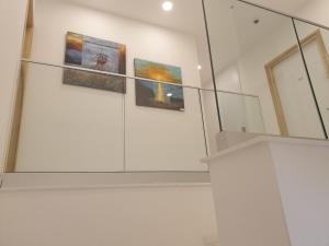 a room with three paintings on a wall at Hai Hotel in Larnaca