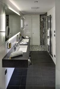 a bathroom with two sinks and a shower at ARTHOTEL Kiebitzberg in Havelberg