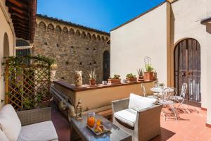 une terrasse avec des chaises en osier et une table. dans l'établissement B&B San Remigio, à Florence