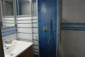 a shower with a blue glass door next to a sink at Attico Galilei Fronte Mare by Salentoville Gallipoli in Gallipoli +23 photos