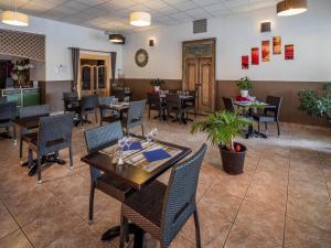 un restaurante con mesas y sillas en una habitación en Noemys Aigues-Mortes - Hotel avec piscine, en Aigues-Mortes