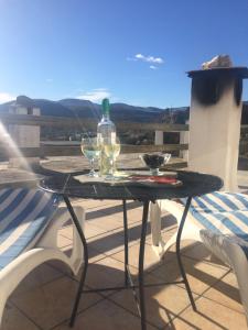 - une table avec 2 verres à vin et une bouteille dans l'établissement Villa Ugijar, à Ugíjar