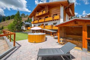 eine Terrasse mit einem großen Gebäude mit einem Whirlpool in der Unterkunft San Martino Mountain Residence in San Martino di Castrozza