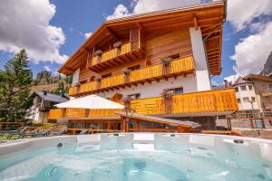 un edificio con una grande piscina di fronte a un edificio di San Martino Mountain Residence a San Martino di Castrozza