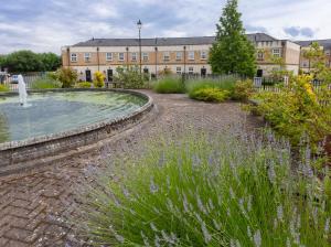 a garden with a fountain in front of a building at Thomas, off Leeman Road, Sleeps 9 in York