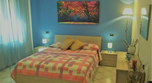 ein Schlafzimmer mit einem Bett, zwei Tischen und einem Gemälde in der Unterkunft House Procaccini, 20 in Bologna