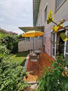 肯普滕的住宿－Garten Apartment Kempten，一个带桌子和遮阳伞的庭院