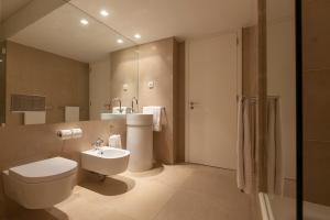a bathroom with a toilet and a sink and a shower at Troia Residence by The Editory - Apartamentos Marina in Troia