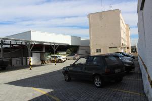 a car parked in a parking lot next to a building at Limeira Plaza Hotel in Limeira