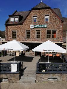 two white umbrellas in front of a building at Gasthaus Rosenberg in Klotten