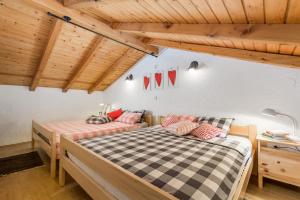 two beds in a room with wooden ceilings at House Pavincic in Lovran +33 photos