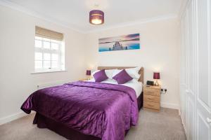 a bedroom with a purple bed and a window at Thomas, off Leeman Road, Sleeps 9 in York