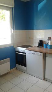 uma cozinha com um fogão branco e uma parede azul em Foreword House em Albert
