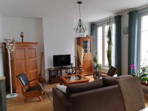 - un salon avec un canapé et des chaises dans l'établissement Brest quartier Siam appartement 3 étoiles, à Brest