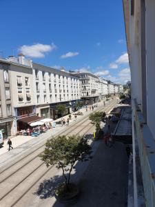 une rue urbaine avec des bâtiments et des gens qui marchent dans la rue dans l'établissement Brest quartier Siam appartement 3 étoiles, à Brest