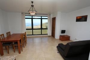 sala de estar con mesa y comedor con vistas en viviendas de uso turístico FINISTERRAE PLAYA, en Finisterre