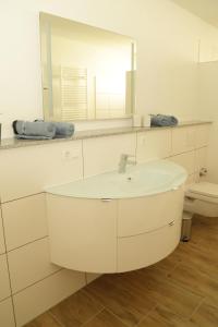 a white bathroom with a sink and a mirror at Riethelblick in Volkesfeld