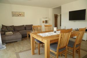 uma sala de estar com uma mesa de madeira e cadeiras em Riethelblick em Volkesfeld