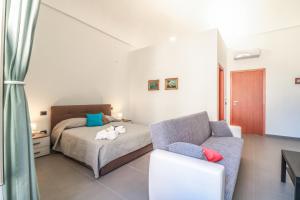um quarto com uma cama e um sofá em Villa Annunziata B&B em Ercolano