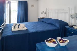 a bedroom with a bed with blue sheets and a bowl of fruit at Chibao in Ragusa