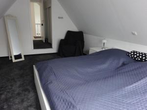a bedroom with a bed and a chair and a mirror at Ferienhaus mit Kamin in Xanten