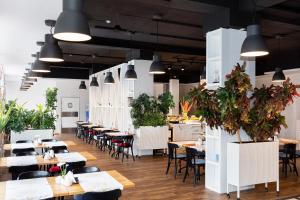 a restaurant with tables and chairs and potted plants at Rezydencja Bielik in Międzyzdroje