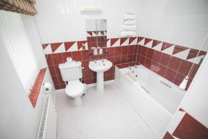 a bathroom with a toilet and a sink and a tub at The Oakwheel in Scarborough +30 photos