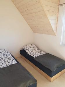two beds in a room with a roof at DOMKI "apartamenty 4maki" in Jastrzębia Góra