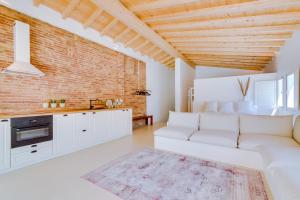 a living room with a white couch and a brick wall at Casa do Chico in Olhão
