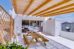 an outdoor patio with a table and a bench at Casa do Chico in Olhão