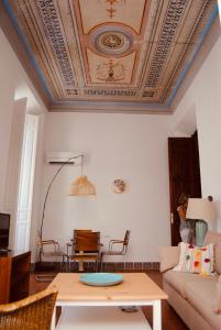 un soggiorno con soffitto a cassettoni e tavolo di Luz y Sencillez en el Centro Histórico de Málaga a Málaga