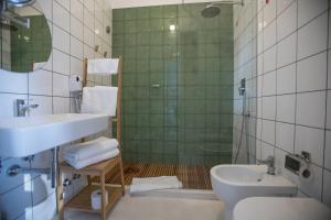 e bagno con lavandino, servizi igienici e doccia. di Senia_rooms_vista a Santa Maria al Bagno