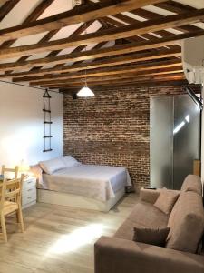 a bedroom with a bed and a couch in a room at Gran Vía apartamentos de temporada in Madrid