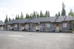 una cabaña de madera con un aparcamiento enfrente en Lost Inn Cabins, en Äkäslompolo
