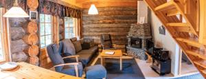sala de estar con sofá y chimenea en Lost Inn Cabins, en Äkäslompolo
