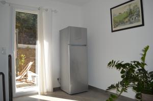 a refrigerator in a room next to a window at La Villa Volpaso in Belgodère