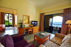 een woonkamer met een bank en een tafel met een televisie bij Island View Resort in Sharm El Sheikh