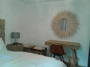 1 dormitorio con cama y escritorio con espejo en Blomatu II Top Floor en Saas-Fee